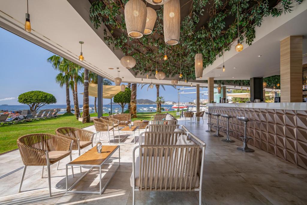 a restaurant with tables and chairs and a bar at Hotel Torre del Mar - Ibiza in Playa d'en Bossa