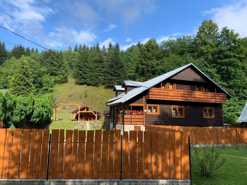 a wooden house with a fence in front of it at VILLA MARTINI in Lazy pod Makytou