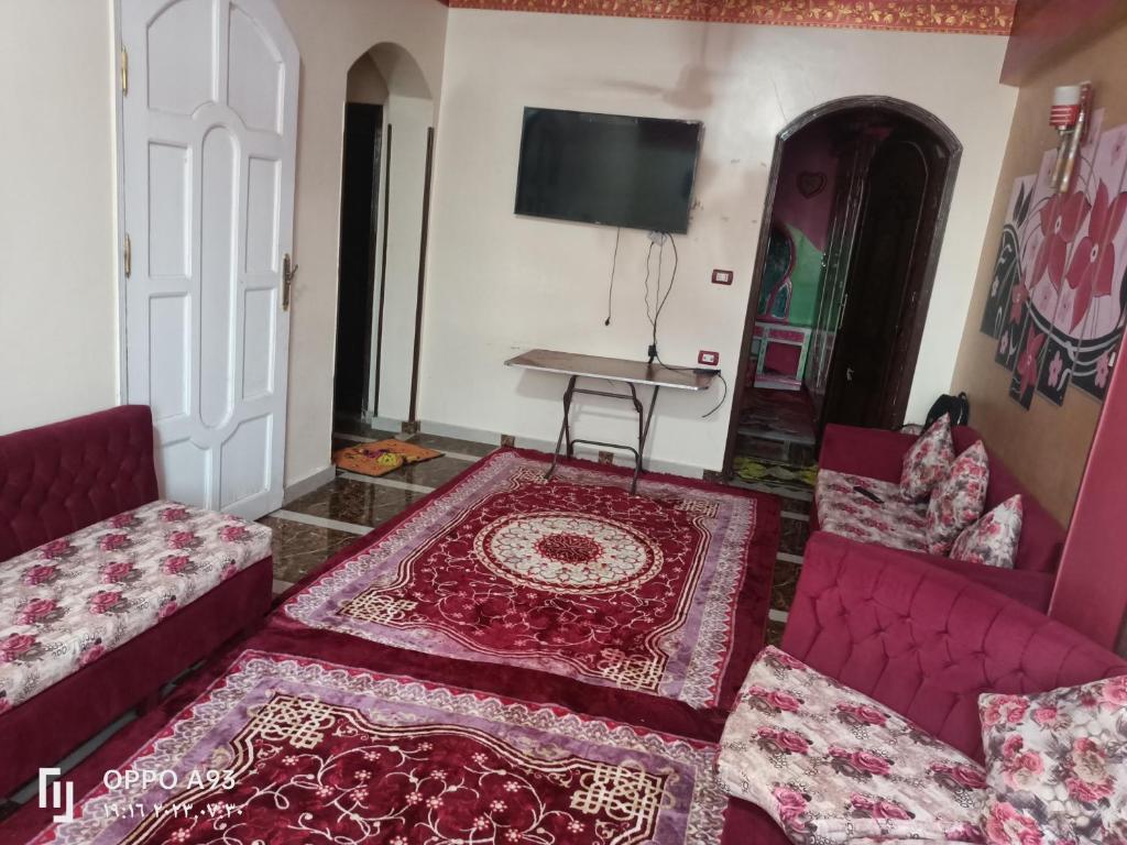 ‘Ezbet Abu Ḥabashi的住宿－sun Ahmed hotel，客厅配有两张沙发和一台电视机