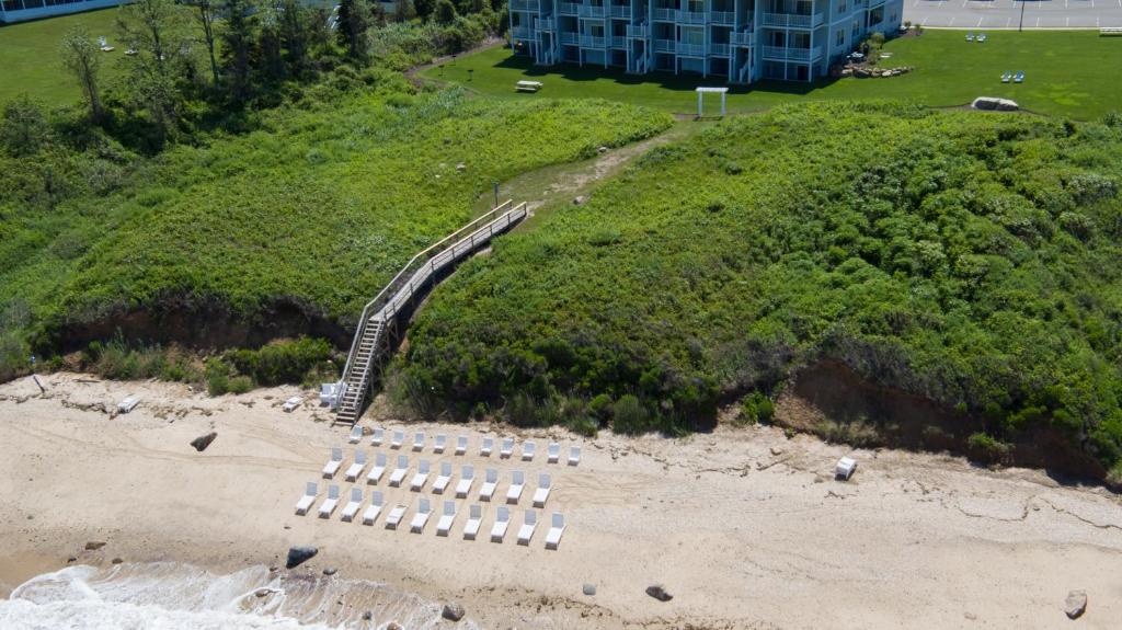 una spiaggia con un mucchio di panchine bianche sulla sabbia di The Cliffside Resort Condominiums a Greenport