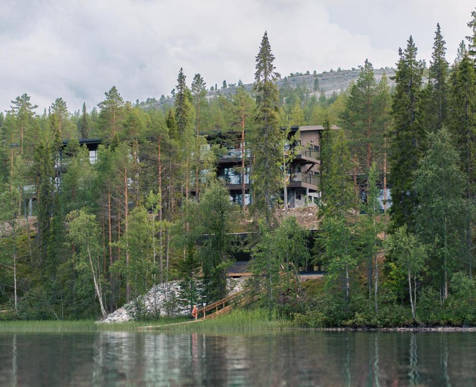um edifício de apartamentos numa colina ao lado de um lago em Kurula's Resort em Pyhätunturi