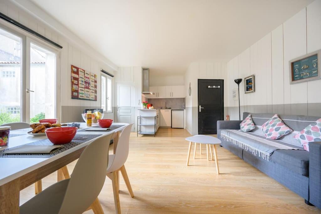 ein Wohnzimmer mit einem blauen Sofa und einem Tisch in der Unterkunft Au cœur de St Martin : Les Grenettes in Saint-Martin-de-Ré