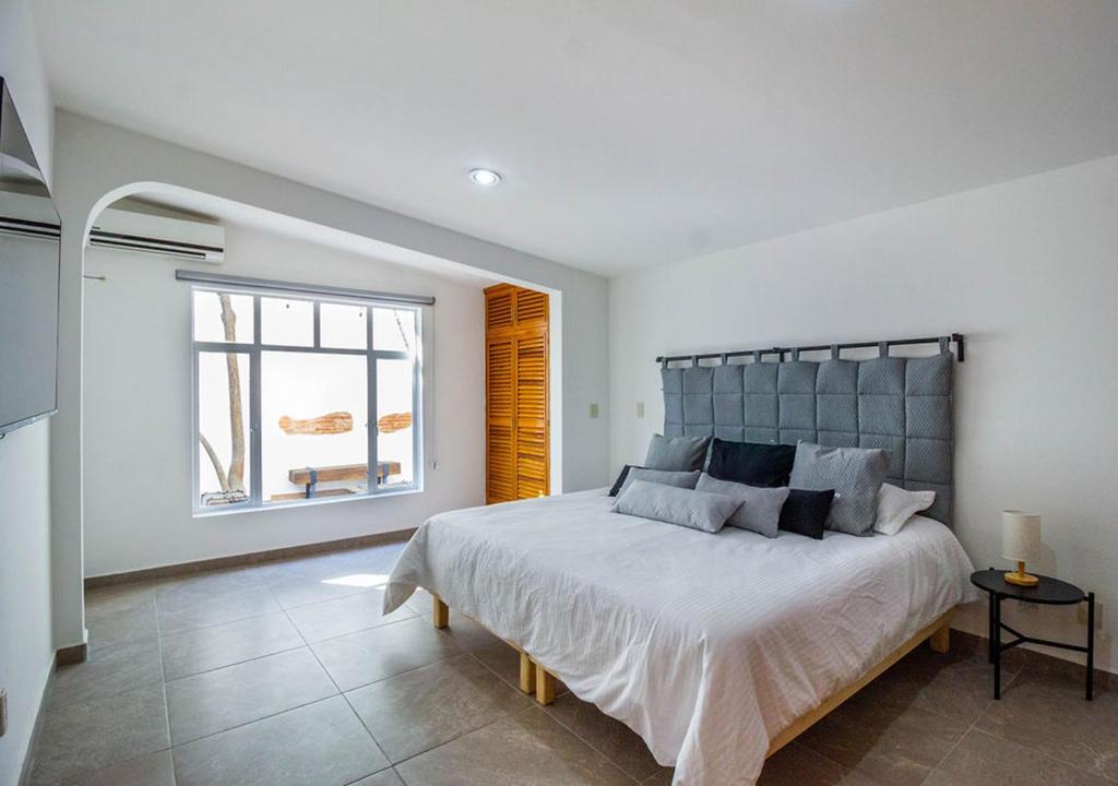 una camera con un grande letto e una finestra di Casa InHome, your home at Oaxaca a Città di Oaxaca