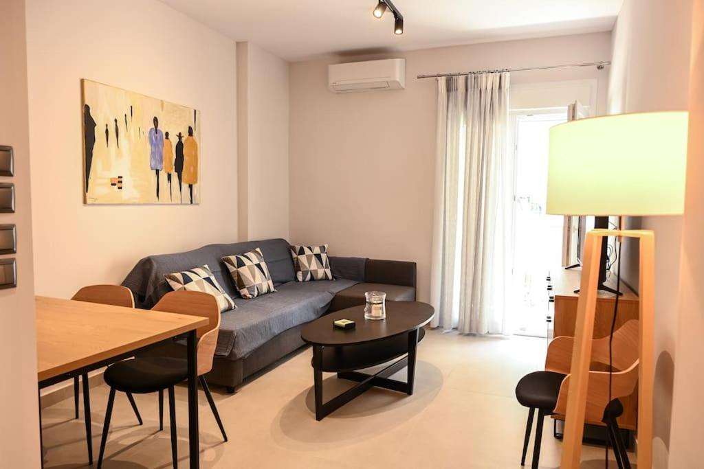 Larisa Hospitality II - St Nicholas apartment - with Free Parking في لاريسا: غرفة معيشة مع أريكة وطاولة