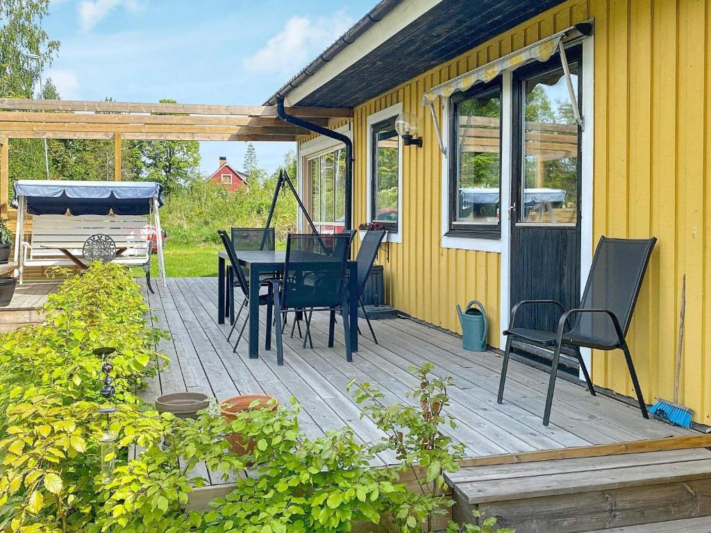 una terraza de madera con mesa y sillas. en Holiday home KIL II en Kil