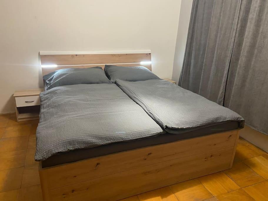 a bed in a bedroom with a wooden bed frame at Family MK Apartment in Prague