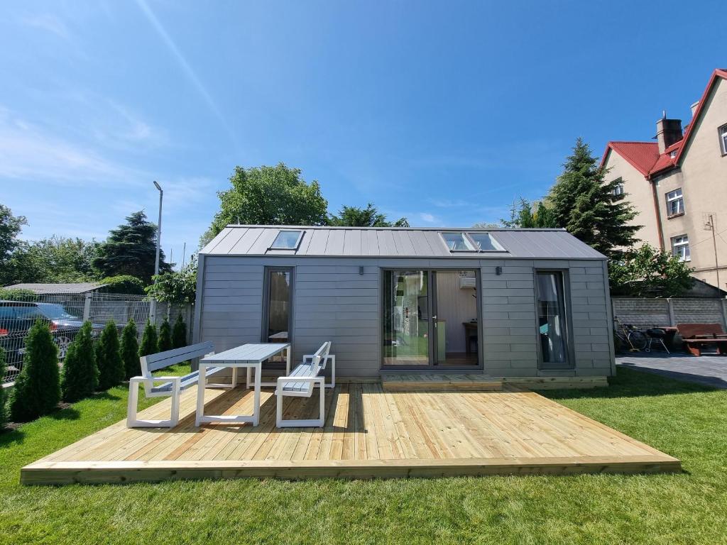 a tiny house with a table and a bench on a deck at Tiny House Jastarnia in Jastarnia