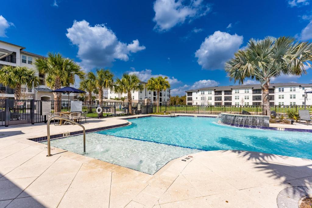 a swimming pool with palm trees and buildings at Eden Ruby Lake 1 bedroom in Orlando