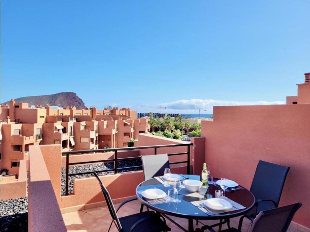 a table on a balcony with a view of a city at Sunny Home La Tejita in Granadilla de Abona