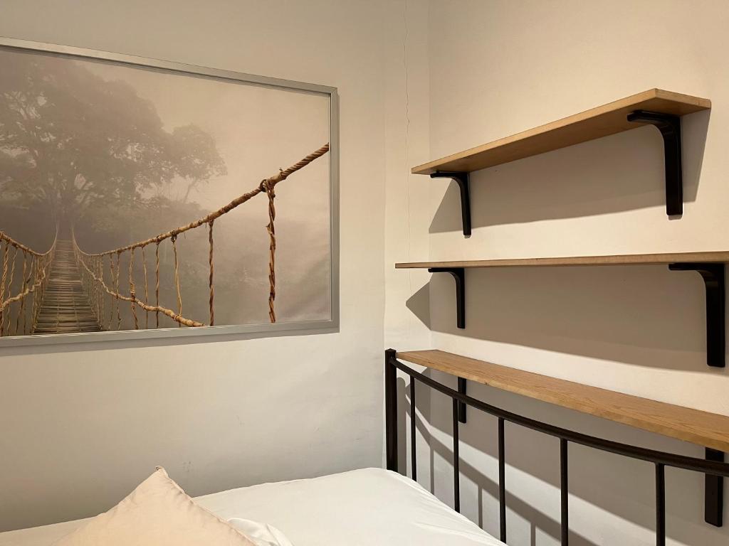 een slaapkamer met een foto van een hangbrug bij mini studio in Néa Michanióna