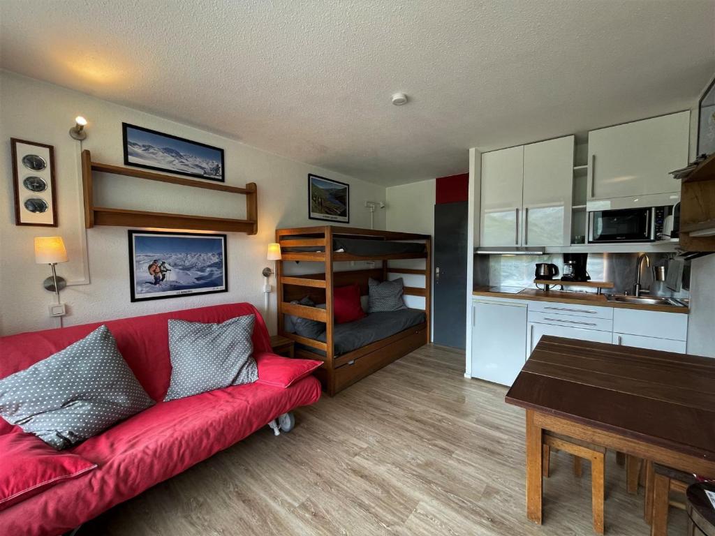 ein Wohnzimmer mit einem roten Sofa und einer Küche in der Unterkunft Studio Les Menuires, 1 pièce, 3 personnes - FR-1-452-281 in Les Menuires