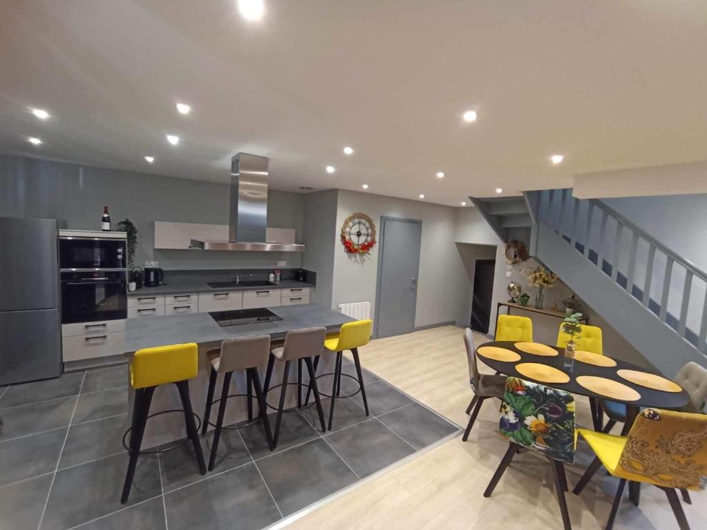 a kitchen and dining room with a table and yellow chairs at Le palais duplex in Autun