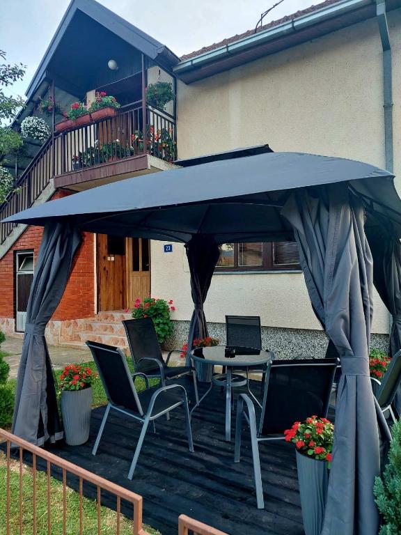 a patio with a table and chairs under a blue umbrella at Rakić apartman in Bajina Bašta