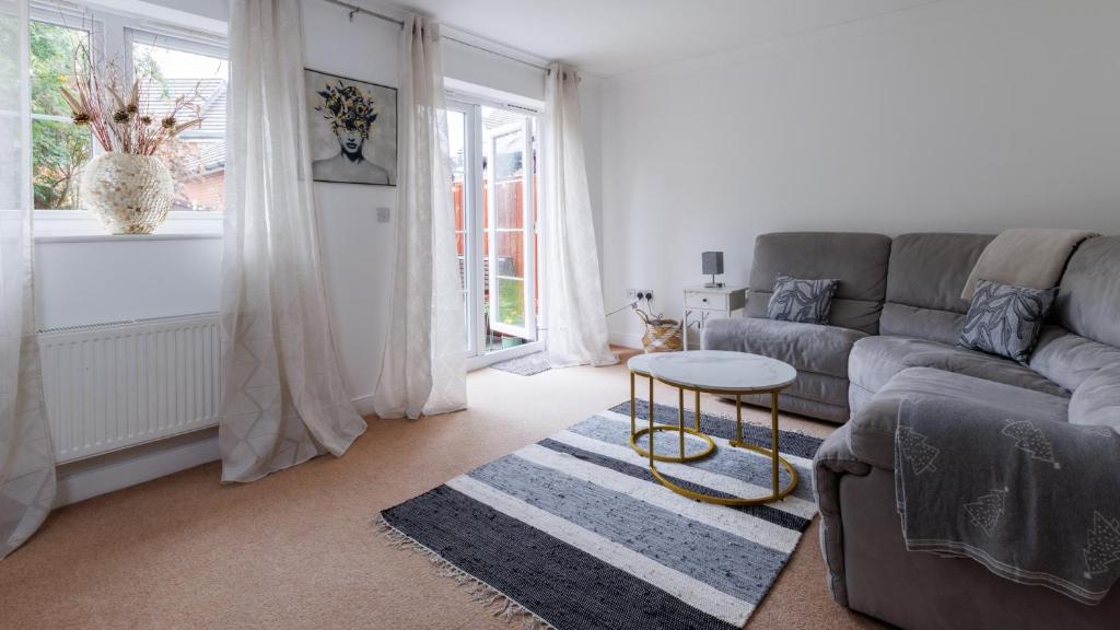 a living room with a couch and a table at Comfortable 4-Bedroom Home in Aylesbury Ideal for Contractors Professionals or Larger Families in Aylesbury