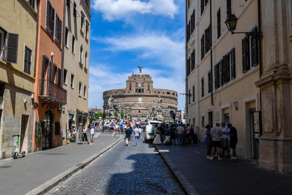 un grupo de personas caminando por una calle con edificios en Castel Sant'Angelo Apartments - Exclusive & Luxury en Roma