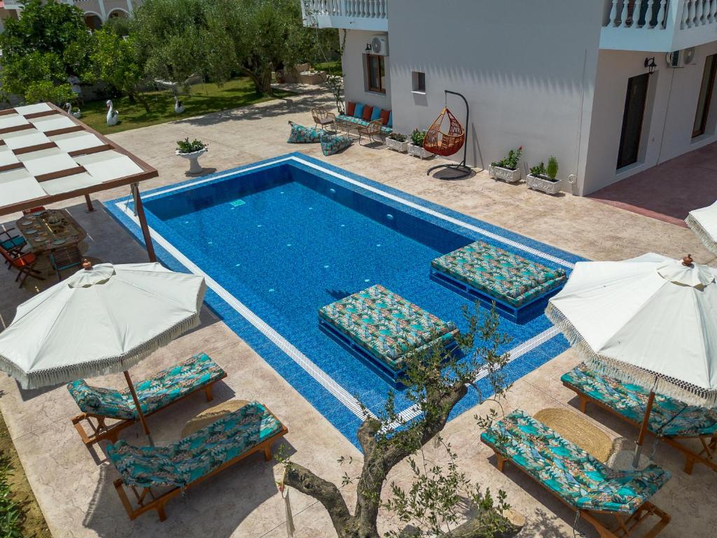 una piscina al aire libre con sillas y sombrillas en Loula's Villa, en Alykes