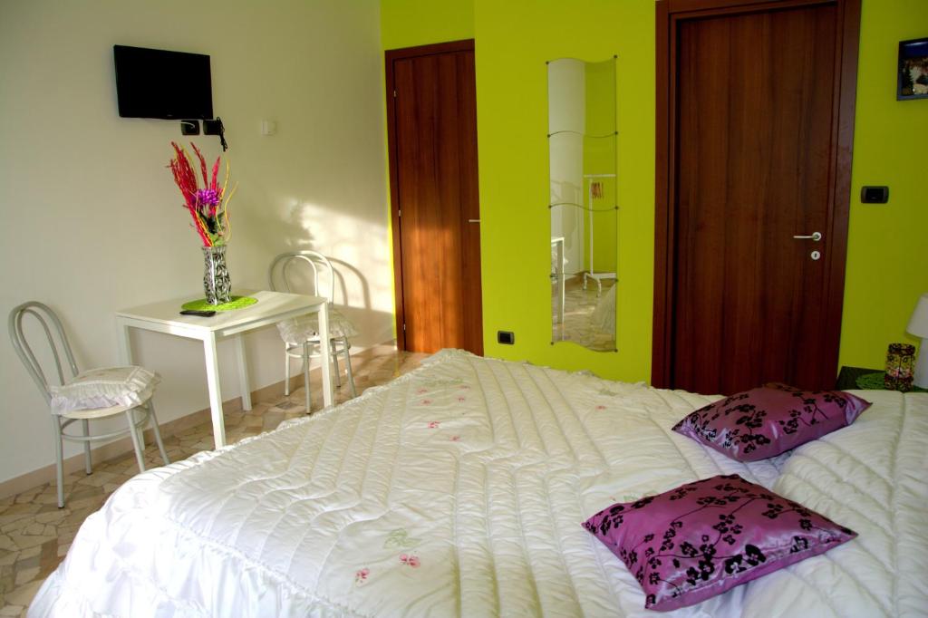 a bedroom with a large white bed with purple pillows at B&B Il Poggio in Villagrande