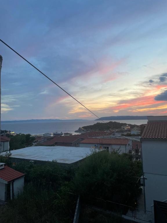 a sunset over a city with a body of water at Chill house in Makarska