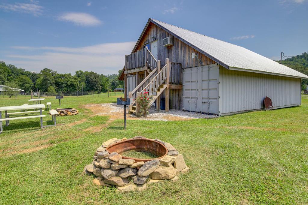 a barn with a pile of logs in front of it at Cozy Huntsville Escape with Brimstone Trail Access! in Huntsville