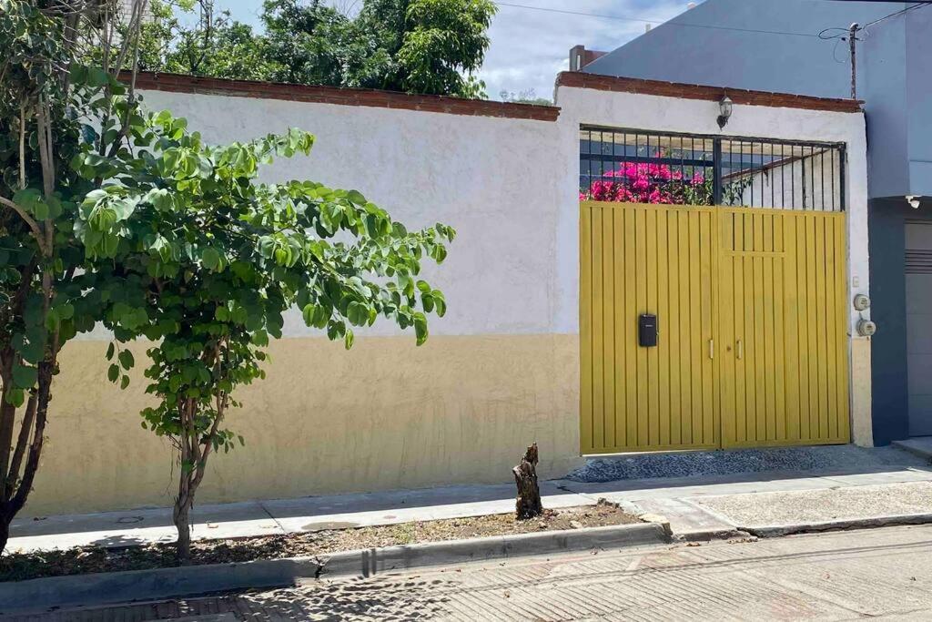 una porta gialla sul lato di un edificio di Casa Leona Oaxaca a Città di Oaxaca