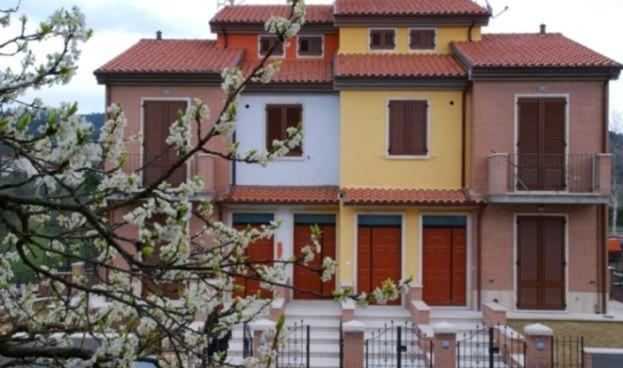 a large house with a yellow and red roof at Appartamenti Le Terme in Rapolano Terme