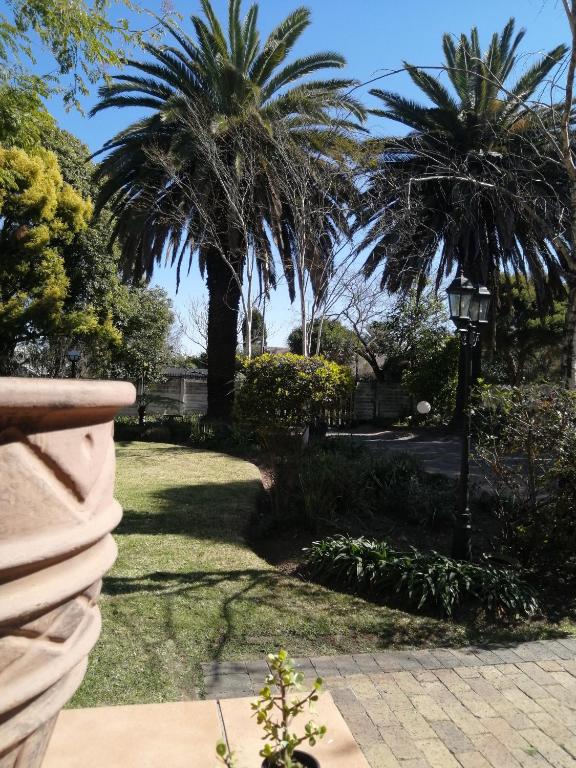 a park with palm trees and a street light at Kaste Guest House Edenvale in Edenvale