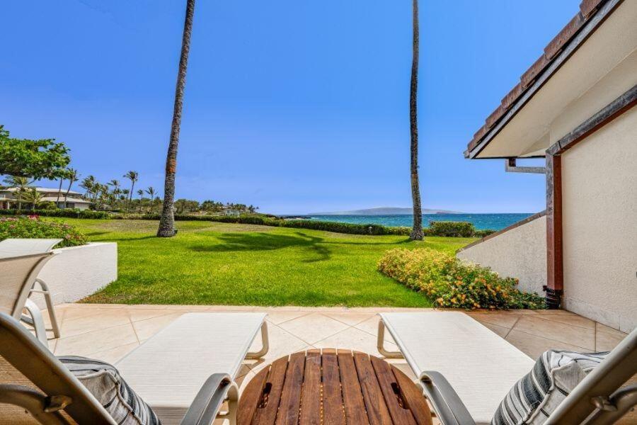 a patio with a table and chairs and the ocean at MAKENA SURF #F-102 condo in Wailea