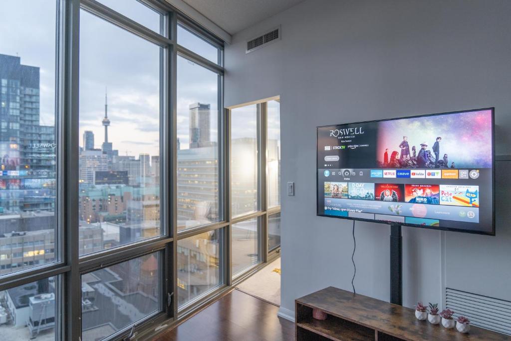 a living room with a large window and a flat screen tv at Lovely 1 bed in Central Toronto in Toronto