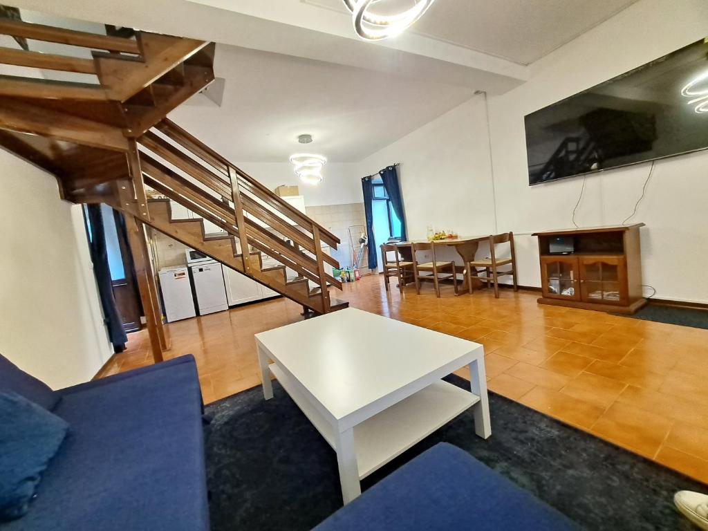 ein Wohnzimmer mit einem weißen Tisch und einer Treppe in der Unterkunft Immobillario - Villa Viva Como in Domaso