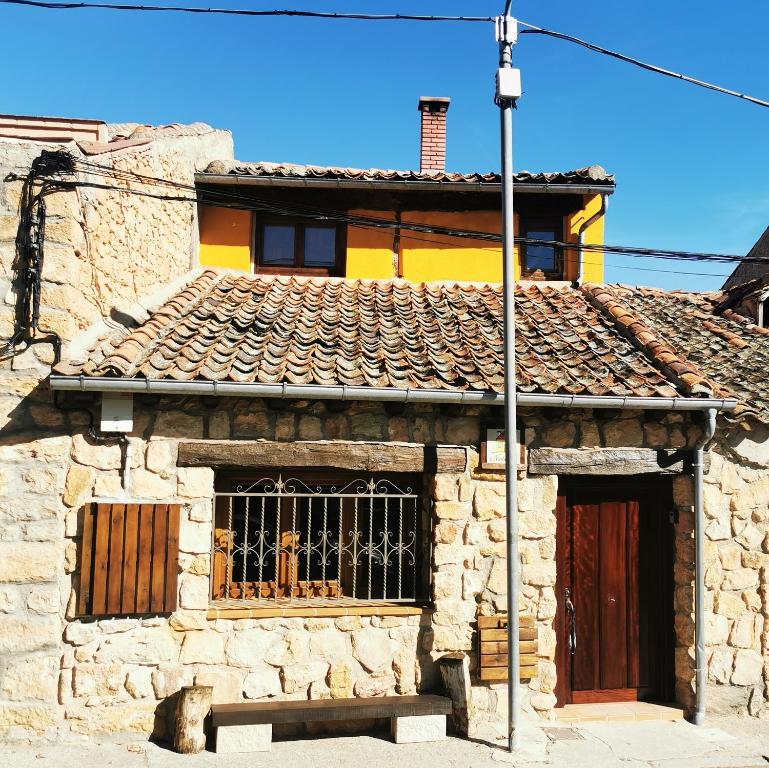 an old stone building with a door and a window at Casita Pirón in Adrada de Pirón