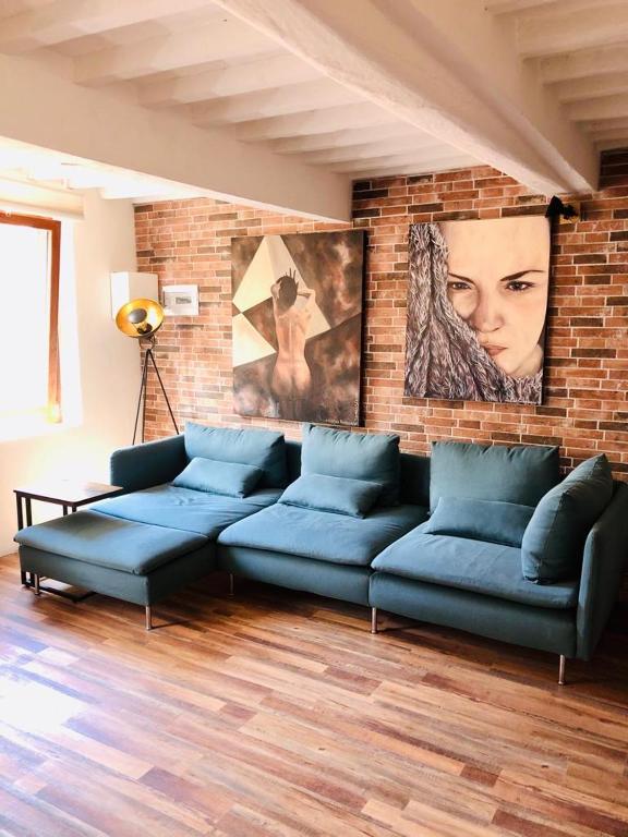 a living room with a blue couch and a brick wall at Casa Torre San Lorenzo in Pisa