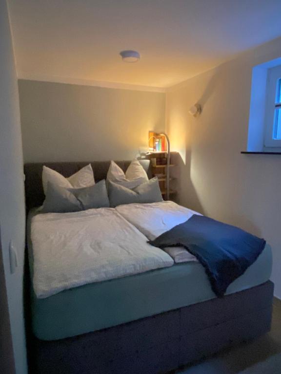 a bedroom with a bed with white sheets and pillows at Moderne großzügige Souterrainwohnung Zarrentin Gallin Schaalsee Natur Wald Wasser in Gallin
