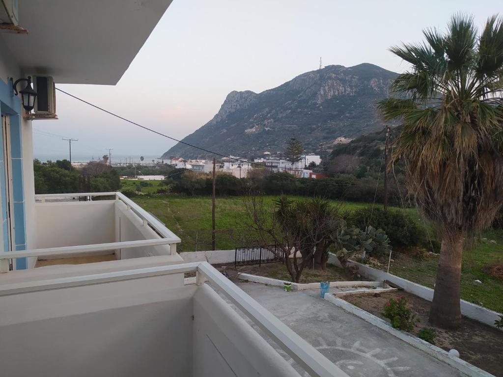 a balcony with a view of a palm tree and a mountain at Dionisia Apartments 2 in Kefalos
