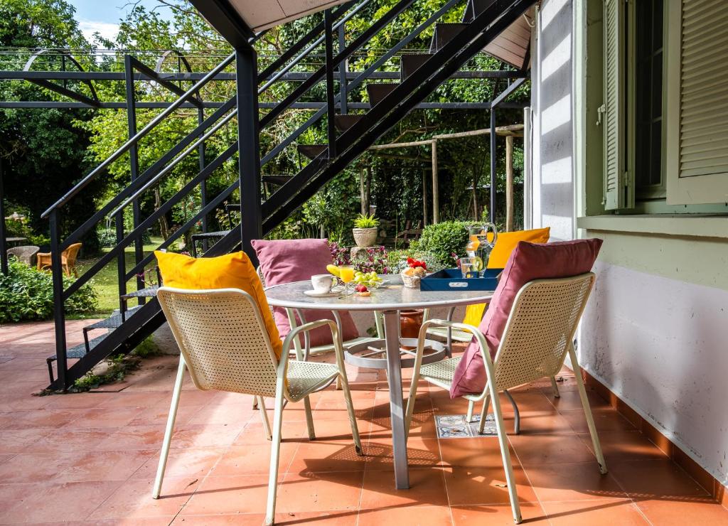 um pátio com uma mesa e cadeiras num alpendre em Uruñuela, un jardín entre viñedos en La Rioja em Uruñuela