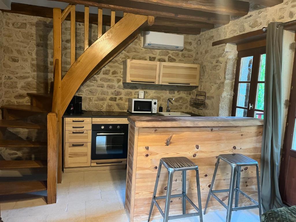 uma cozinha com um balcão e bancos num quarto em maison Saint Berain sur Dheune em Saint-Berain-sur-Dheune