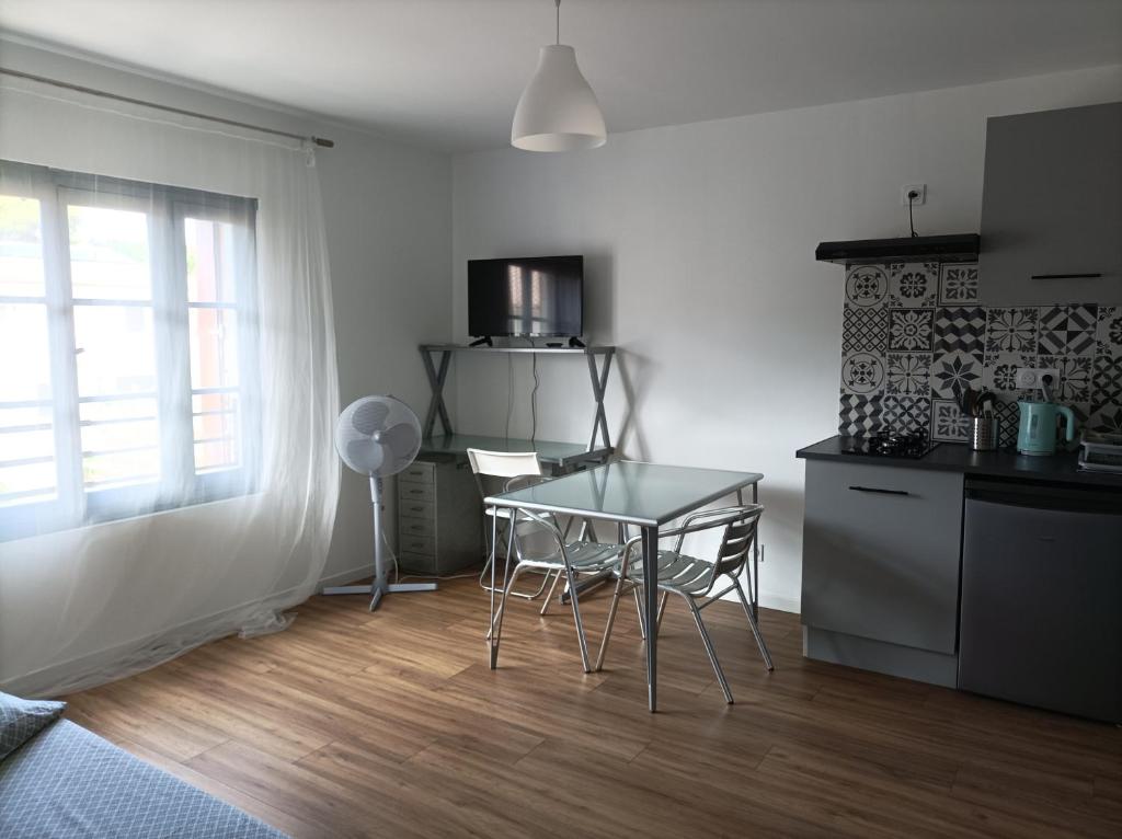 a kitchen with a table and chairs in a room at Studio vue château 100m étang, plage et halles in Mèze