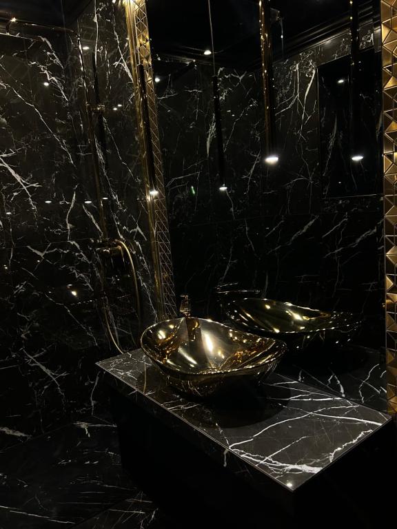 un bagno con due lavandini dorati e uno specchio di LuxuryApartments a Varsavia