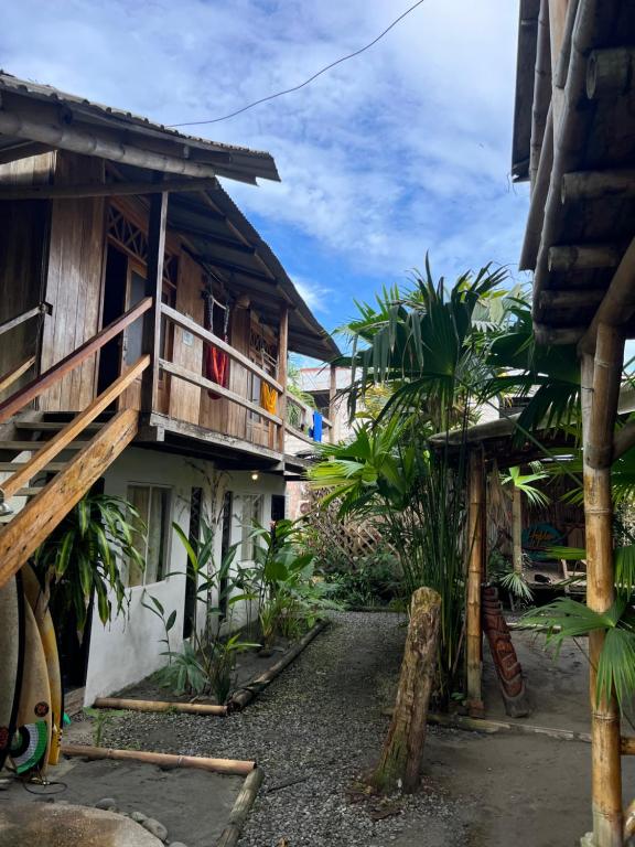 a courtyard of a house with a balcony at Onda Hostel Mompiche in Mompiche