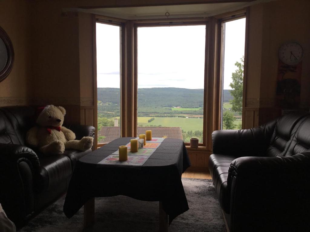 een teddybeer in een woonkamer met een tafel bij House in Røros in Røros