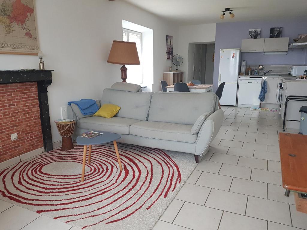 Appartement RDC avec terrasse في Épinac-les-Mines: غرفة معيشة مع أريكة ومدفأة
