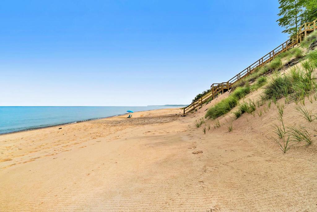 a sandy beach next to the ocean on a clear day at Dune House in Manistee