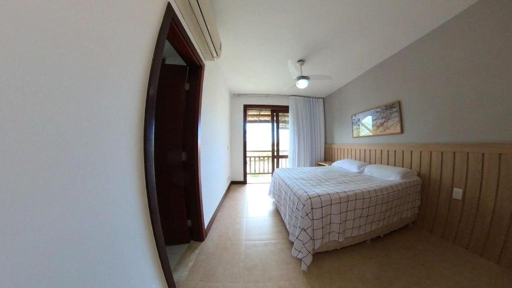 a bedroom with a bed and a large mirror at Reserva Imbassaí Apartamento 3 suites vista mar Td6201 in Mata de Sao Joao
