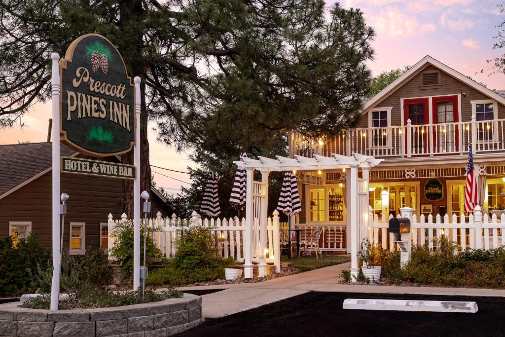 un panneau devant une maison avec une clôture dans l'établissement Prescott Pines Inn, à Prescott