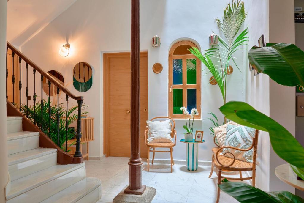 un pasillo con escaleras, sillas y plantas en Casa Vestali, en Granada