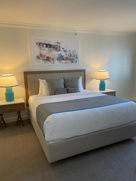 een slaapkamer met een groot bed met 2 lampen bij The Atlantic Hotel & Spa Condo in Fort Lauderdale