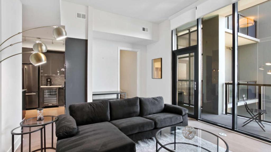 uma sala de estar com um sofá e mesas de vidro em Midtown Luxury Apartment em Atlanta