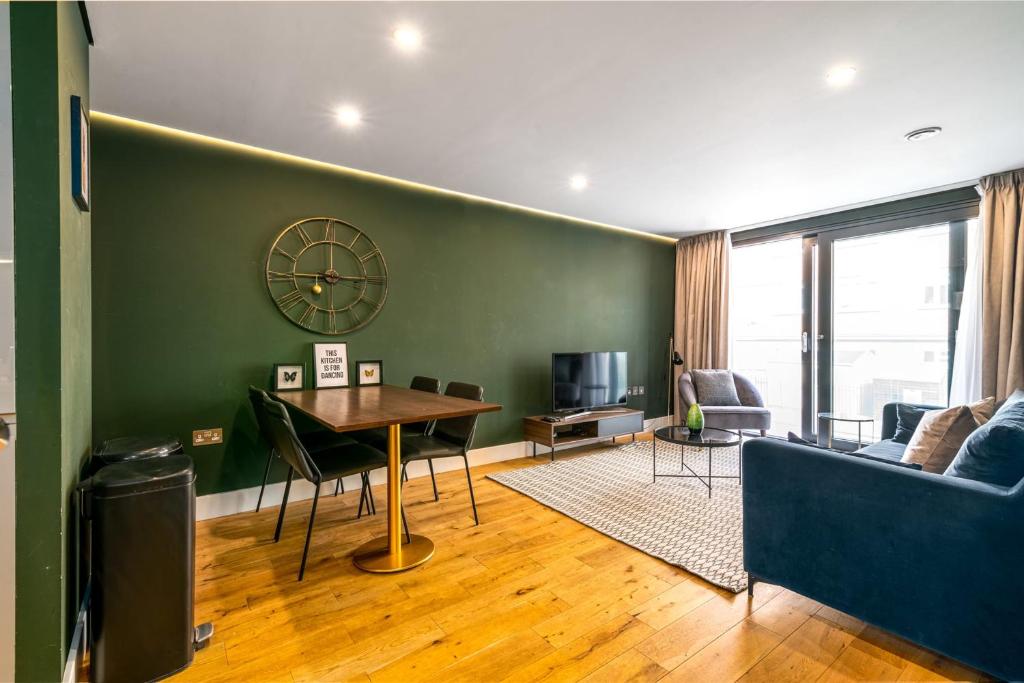 a living room with a table and a green wall at Trendy Kings Cross Flat in London