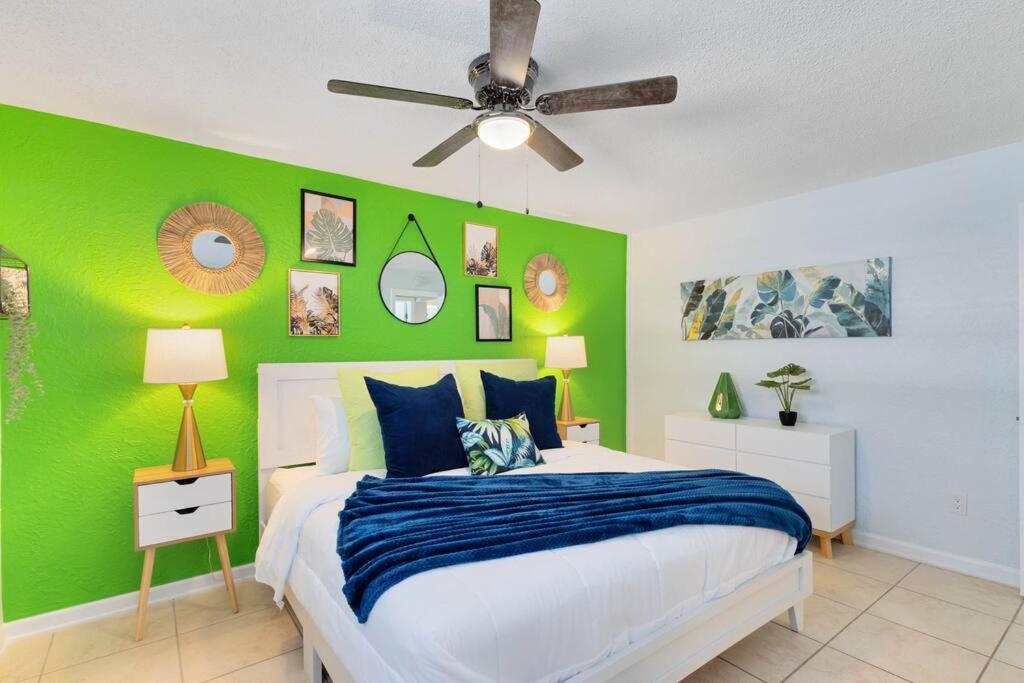 a green bedroom with a bed and a ceiling fan at Beachside 23 in Indian Harbour Beach