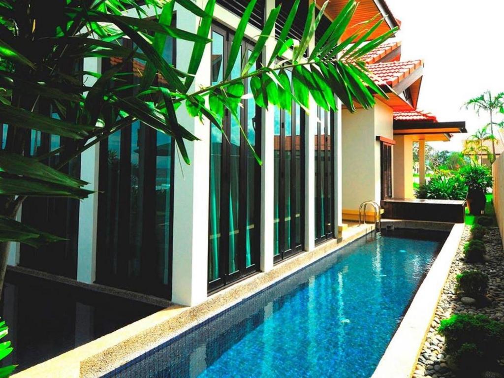 a house with a swimming pool next to a building at Penang 5bedroom Bungalow with pool in Batu Ferringhi
