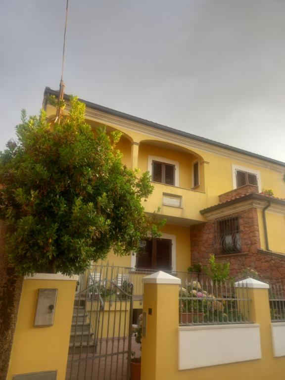 una casa gialla con una recinzione di fronte di La casa delle fate a Giave